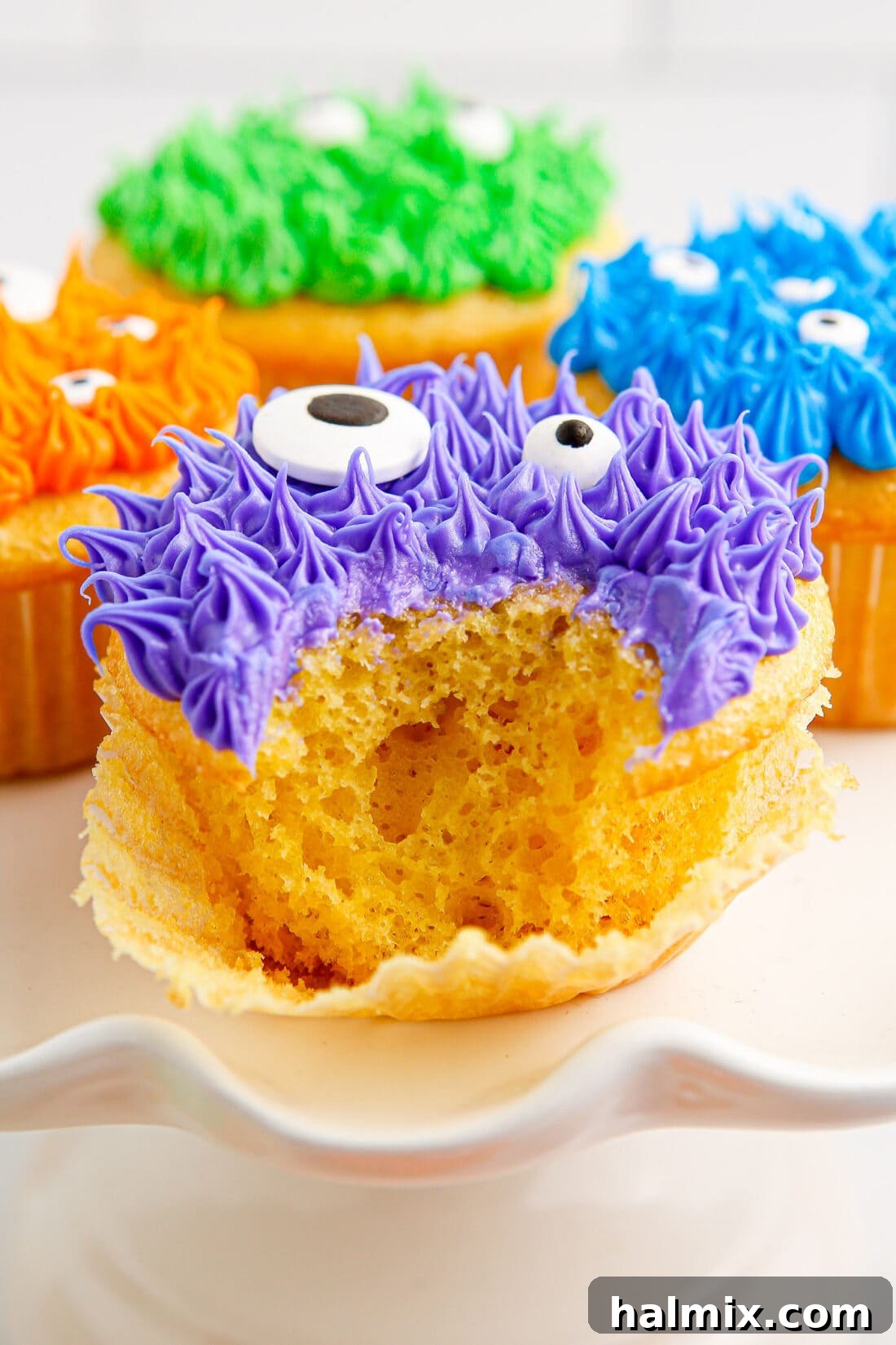 Close up photo of a bite taken out of a Monster Cupcake, showing the colorful frosting and cake texture