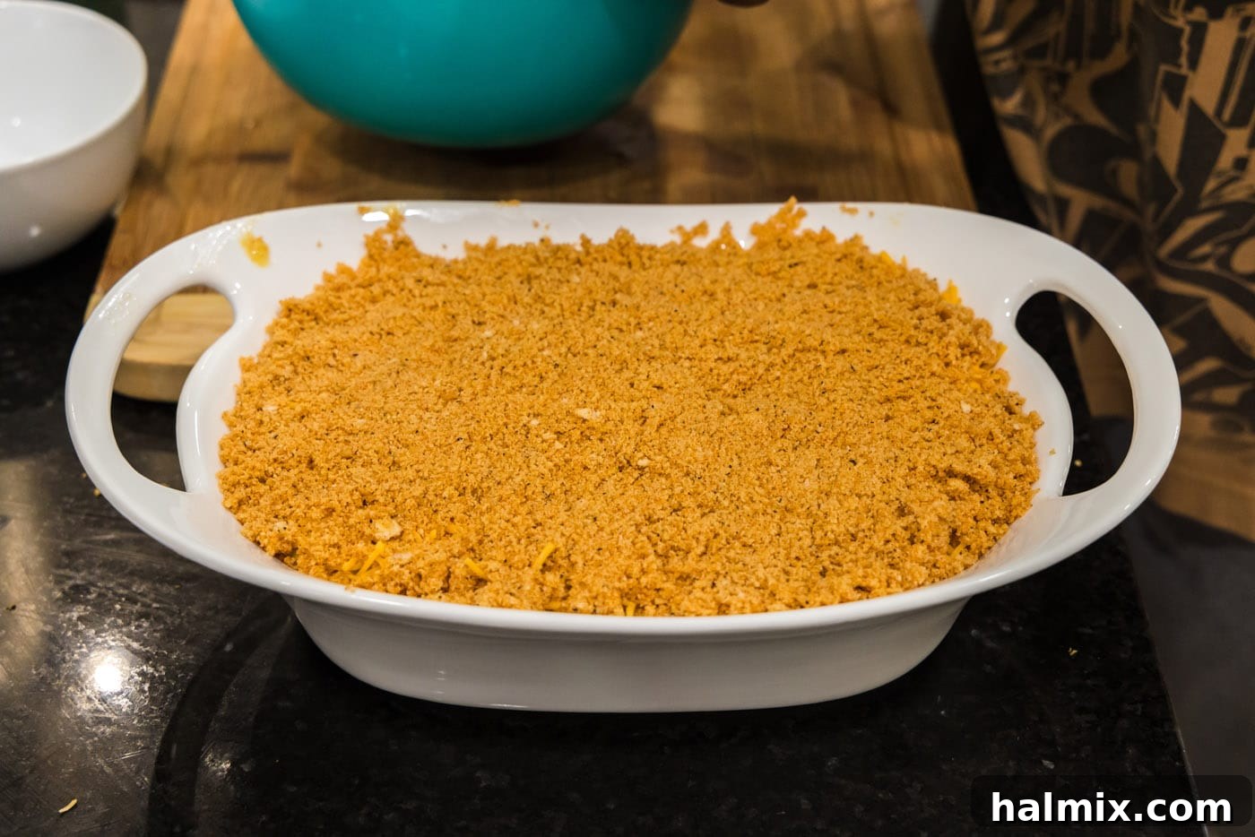 Golden Comfort Corn Bake 14 The completed scalloped corn casserole, topped with seasoned Ritz crackers and cheese, ready to be baked.