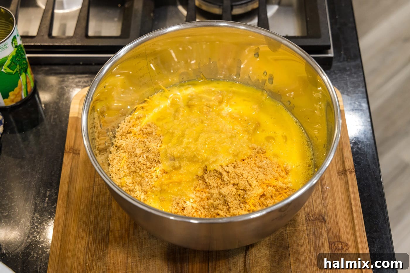 Golden Comfort Corn Bake 10 The reserved Ritz cracker crumbs being added to the corn and cheese mixture, providing internal texture.