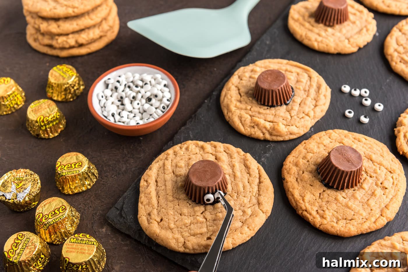 sticking candy eyeballs to peanut butter cup