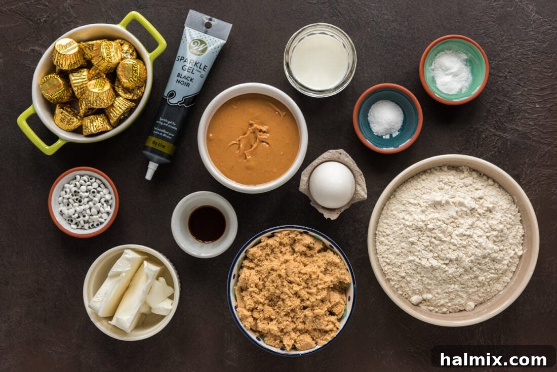 Assortment of ingredients for making spider cookies laid out on a kitchen surface, including peanut butter, flour, sugar, and baking decorations.