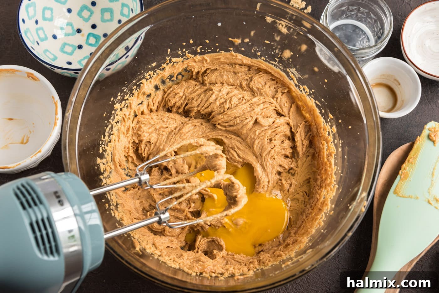 adding egg to peanut butter cookie dough with a mixer