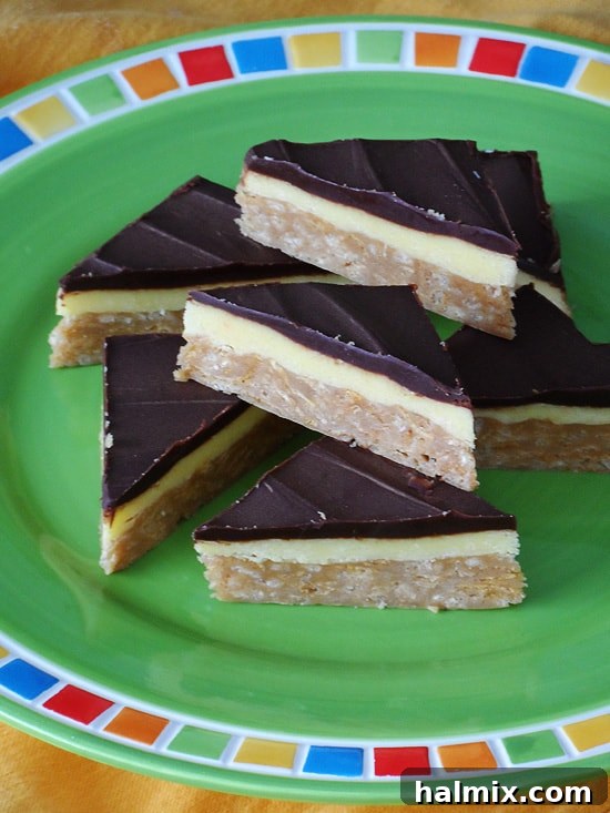 A close-up view of stacked no-bake peanut butter pudding bars on a green plate, highlighting their distinct, delicious layers and textures.