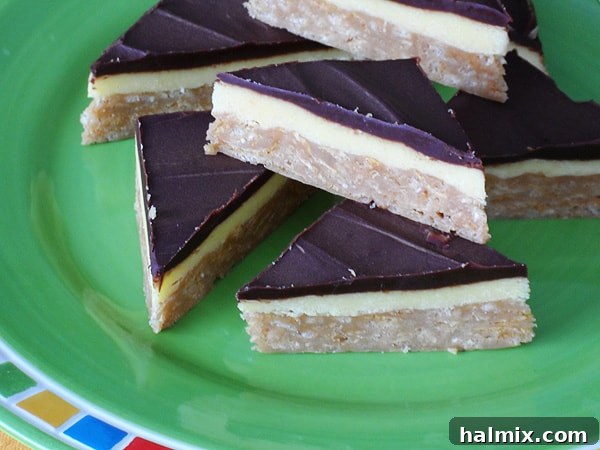A close-up photo of freshly sliced no-bake peanut butter pudding bars presented on a bright green plate, ready for serving.