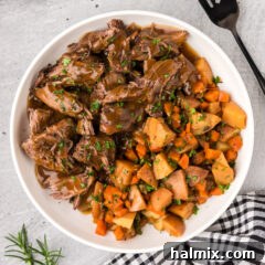 Bowl of Instant Pot Roast Beef with potatoes and carrots on the side