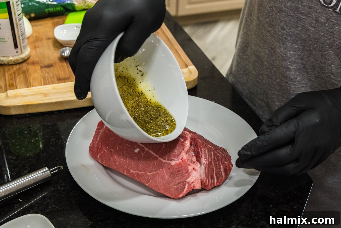 pouring wet rub on top of sirloin tip roast