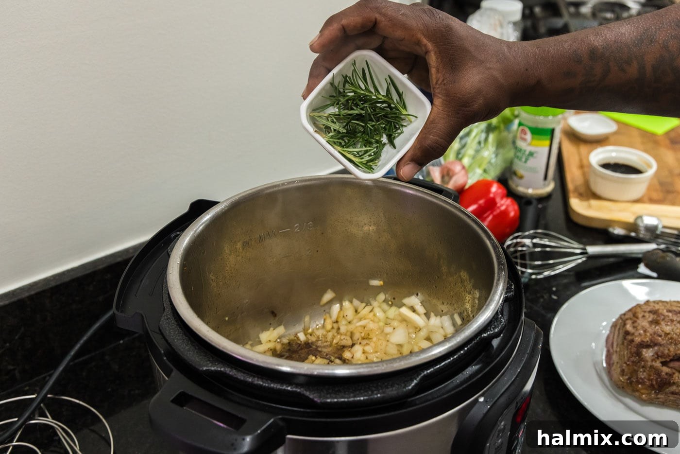 adding rosemary to pot of onions and garlic