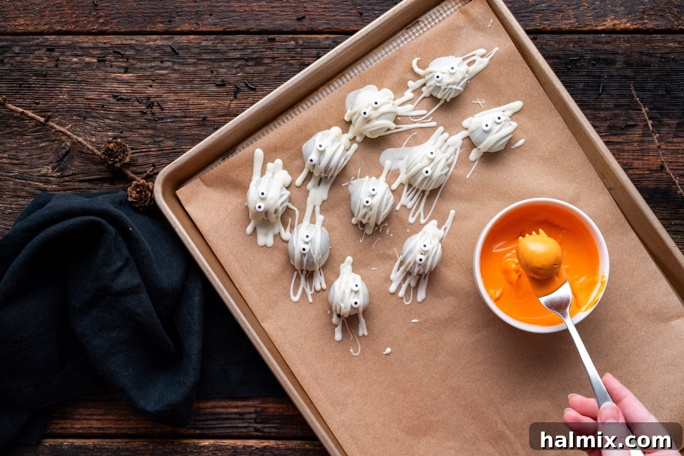 Hauntingly Delicious Oreo Truffles 13 dipping oreo truffle into orange candy melts