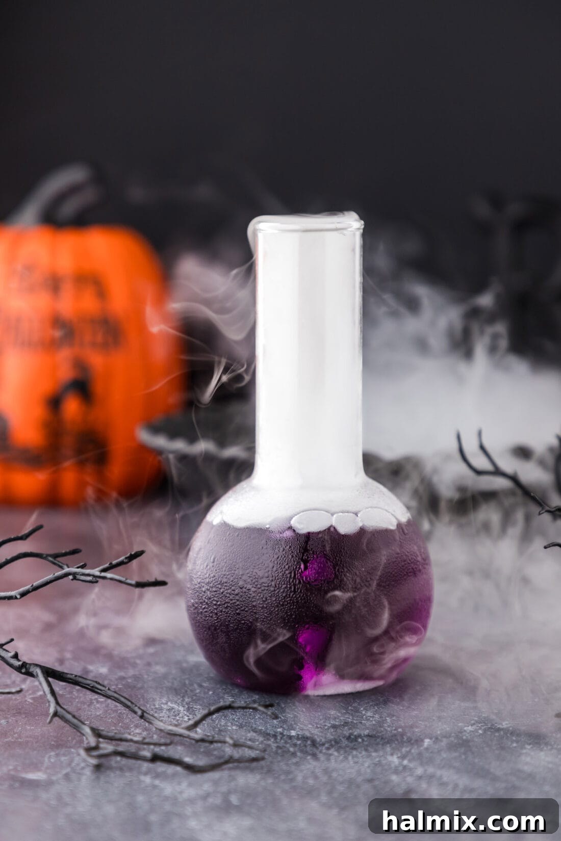 Purple Predator Potion 2 Purple People Eater Cocktail in a beaker glass, emitting a spooky fog