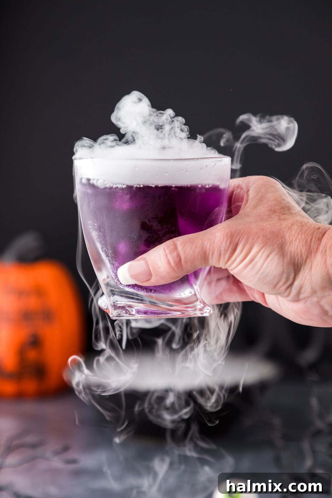 Purple Predator Potion 3 Hand holding up a Purple People Eater Cocktail with fog