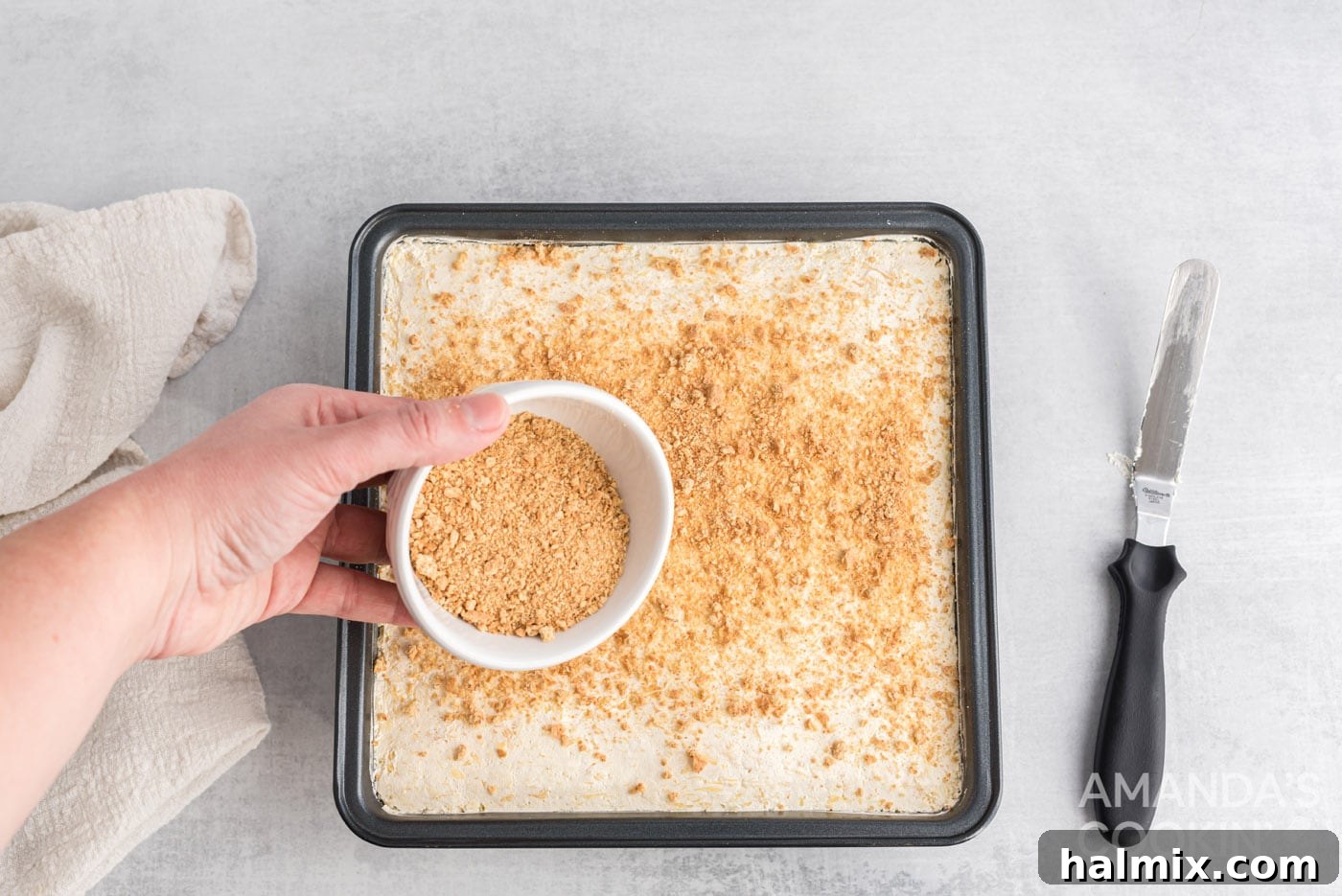 Tropical Pineapple Bliss 11 Remaining graham cracker crumbs being sprinkled as a final garnish over the pineapple dessert.