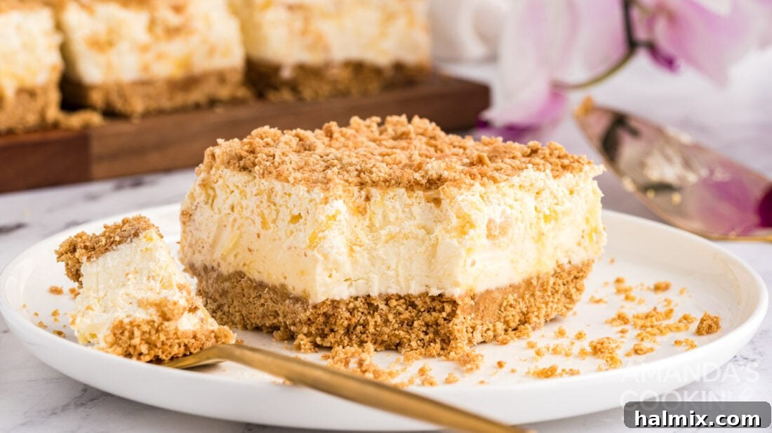 Pineapple Dream Dessert with a Bite Removed A large piece of Pineapple Dream Dessert with a portion taken out, highlighting its delicious layers.