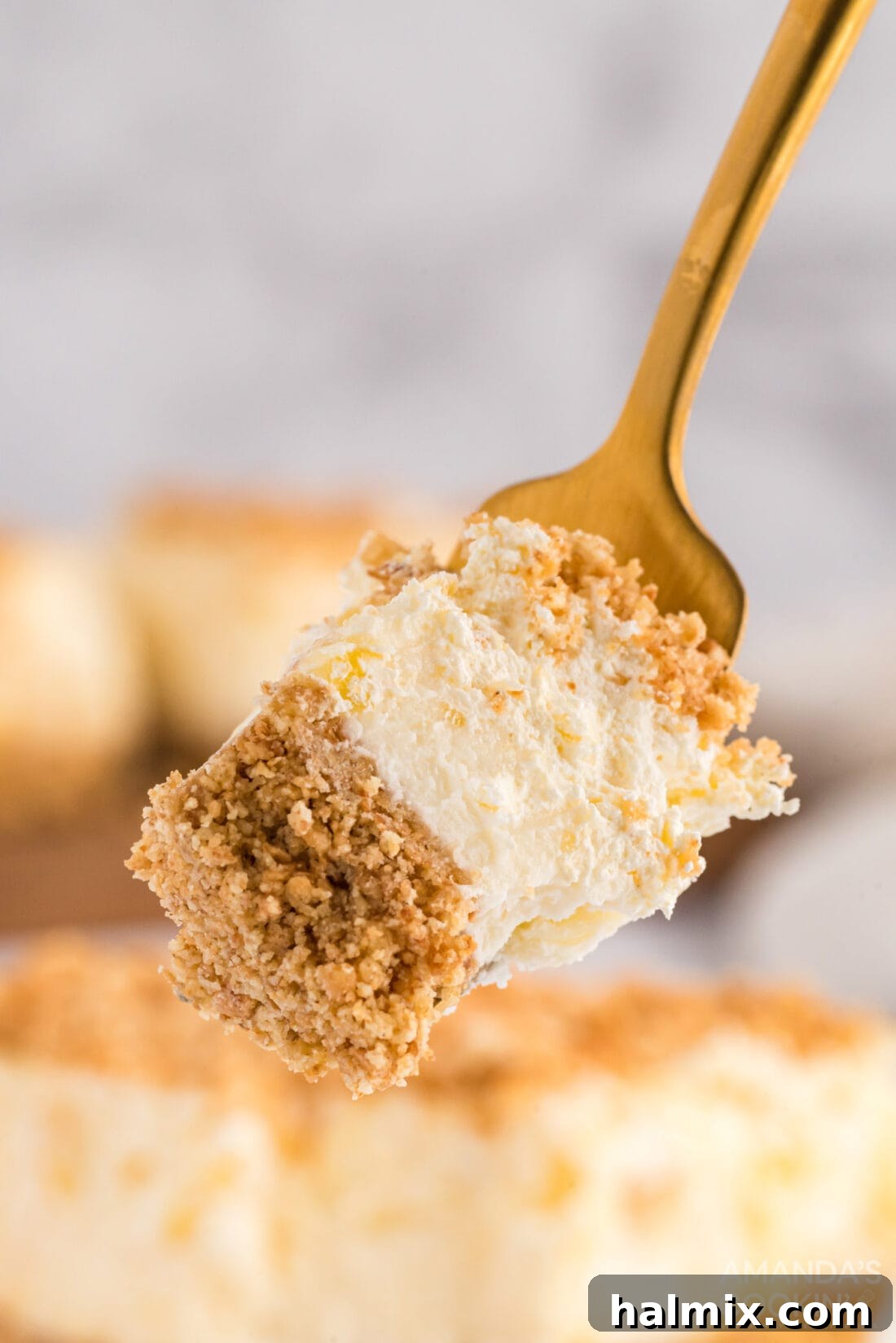 Forkful of Pineapple Dream Dessert Layers A fork lifts a generous bite of the layered Pineapple Dream Dessert, showing its soft and creamy texture.