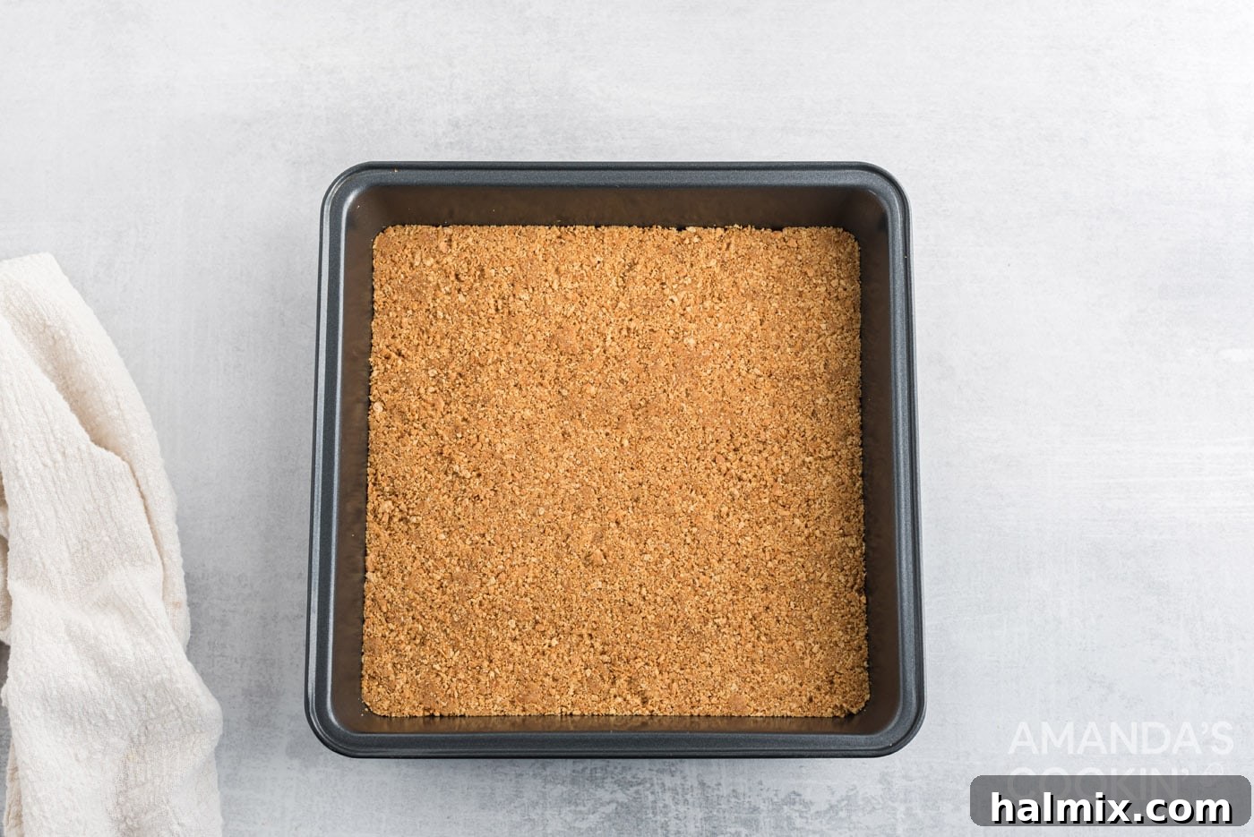 Tropical Pineapple Bliss 5 Graham cracker crumb crust pressed into a square baking pan, ready for the oven.