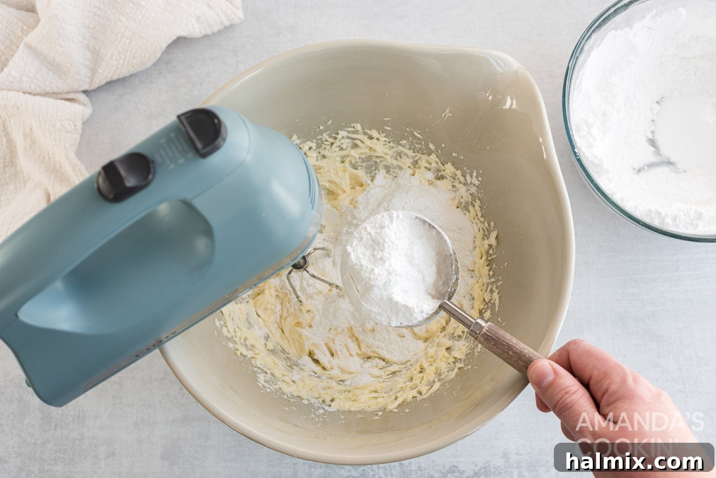 Tropical Pineapple Bliss 6 Powdered sugar being added to a mixer bowl containing cream cheese and butter, creating a smooth filling.