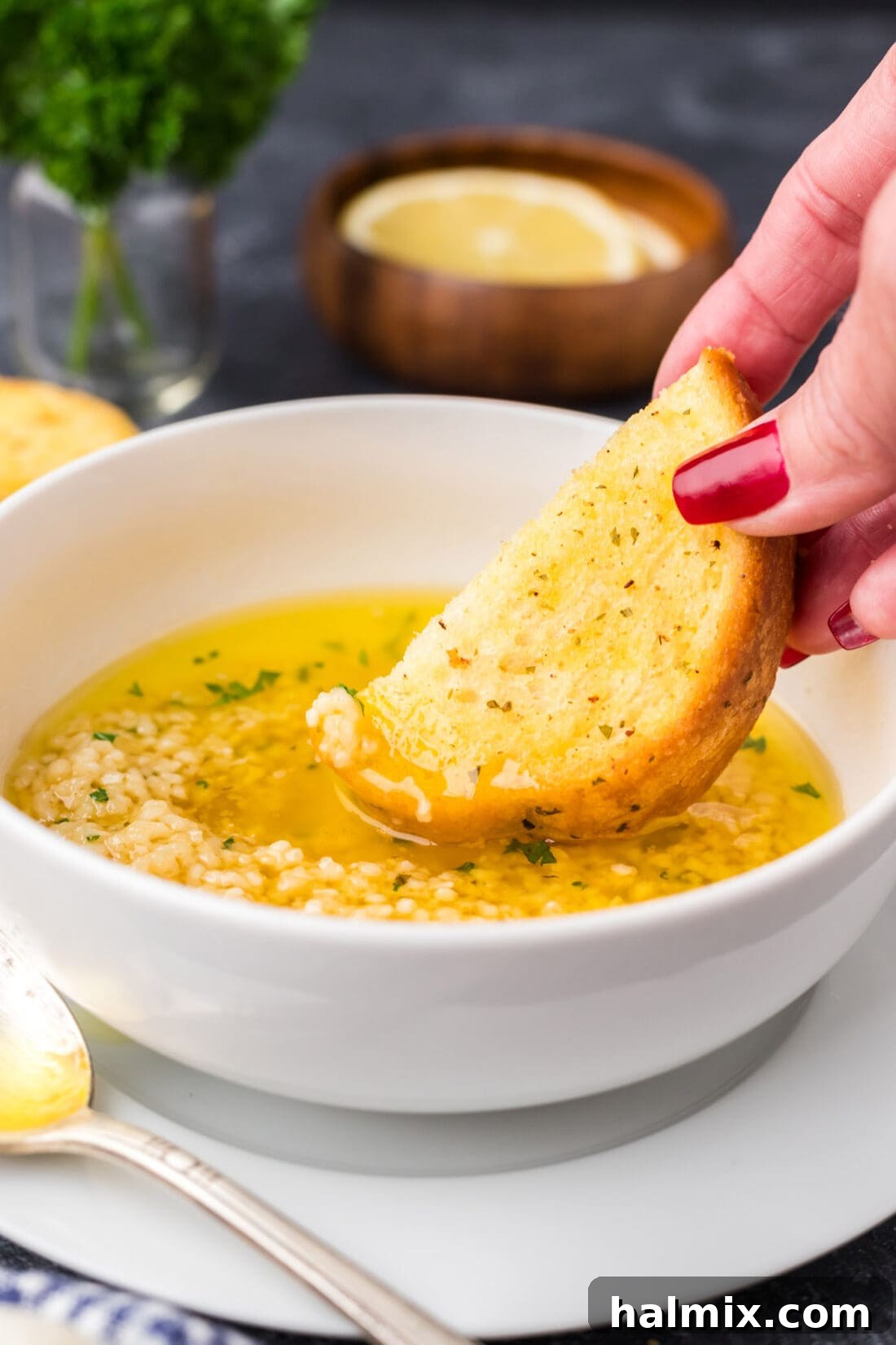 Irresistible Garlic Butter Sauce 2 Piece of bread being dipped into a rich, golden Garlic Butter Sauce, highlighting its creamy texture and inviting aroma.