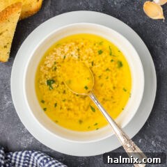 Irresistible Garlic Butter Sauce 12 A bowl of Garlic Butter Sauce with a spoon resting in it, ready for serving.