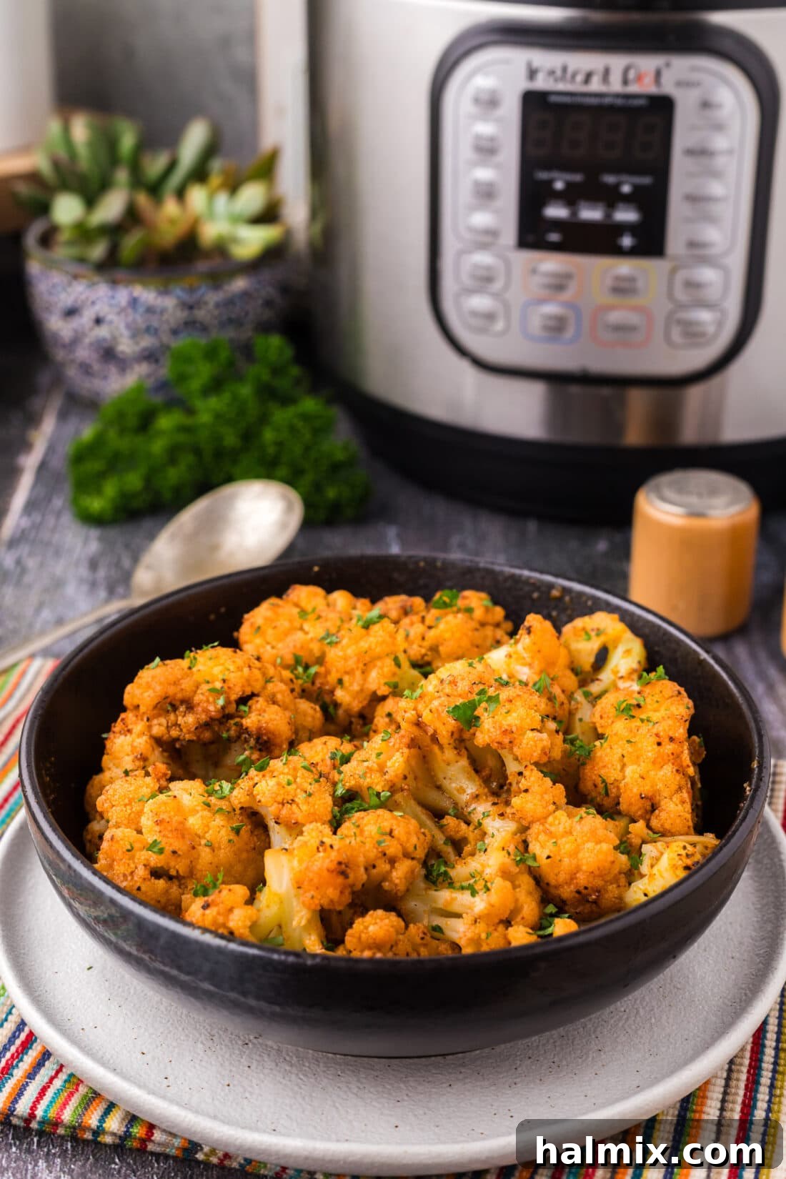 Effortless Instant Pot Cauliflower 2 A vibrant bowl of Instant Pot Cauliflower ready to serve, with the Instant Pot visible in the background, highlighting its quick preparation.