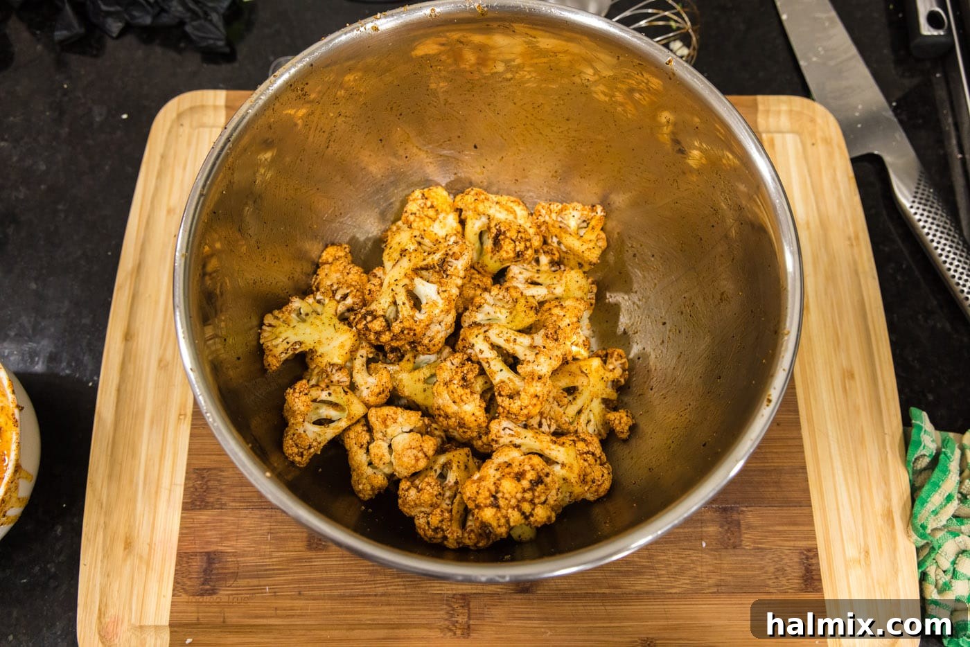 Effortless Instant Pot Cauliflower 6 Cauliflower florets in a large mixing bowl, meticulously coated with the olive oil and spice mixture, ready for cooking.