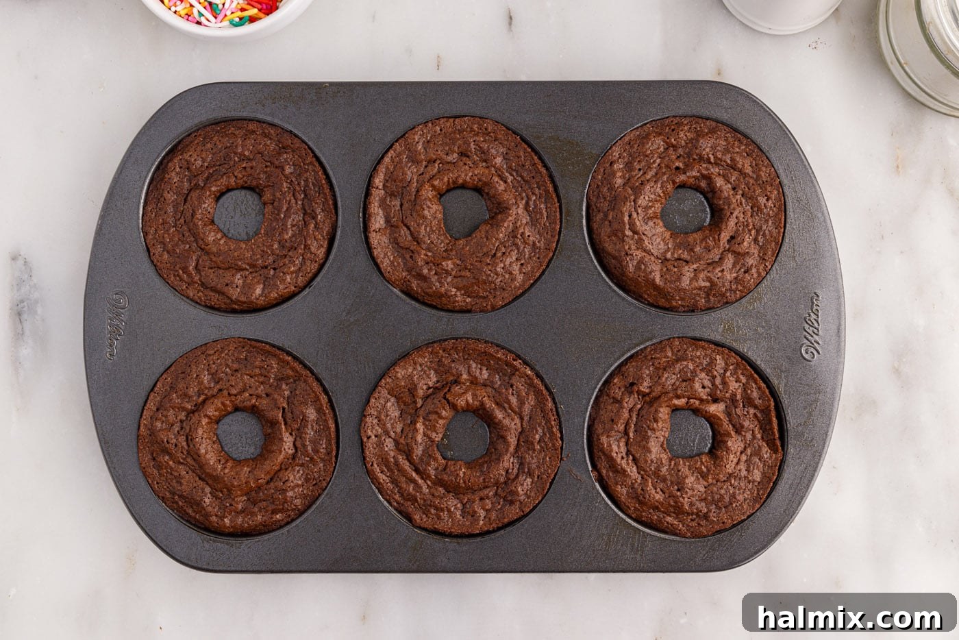 Freshly baked bronuts still in the donut pan