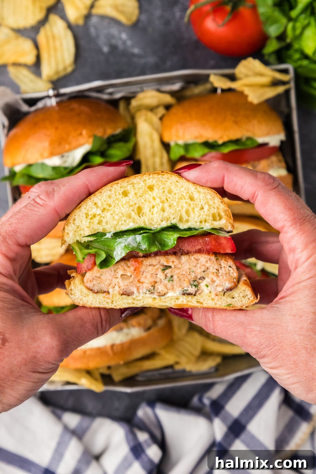 Hands holding up a half of a Salmon Burger