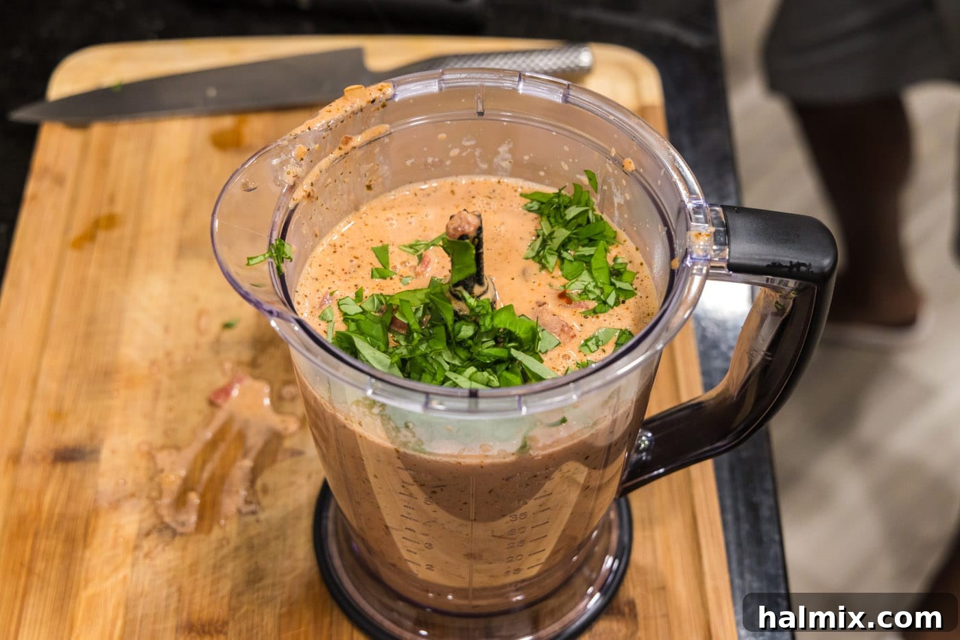 blitzing vodka sauce in a food processor with fresh basil leaves