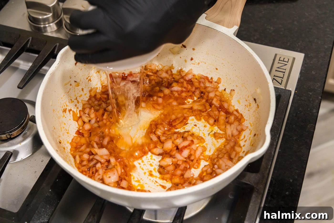 pouring vodka into tomato sauce