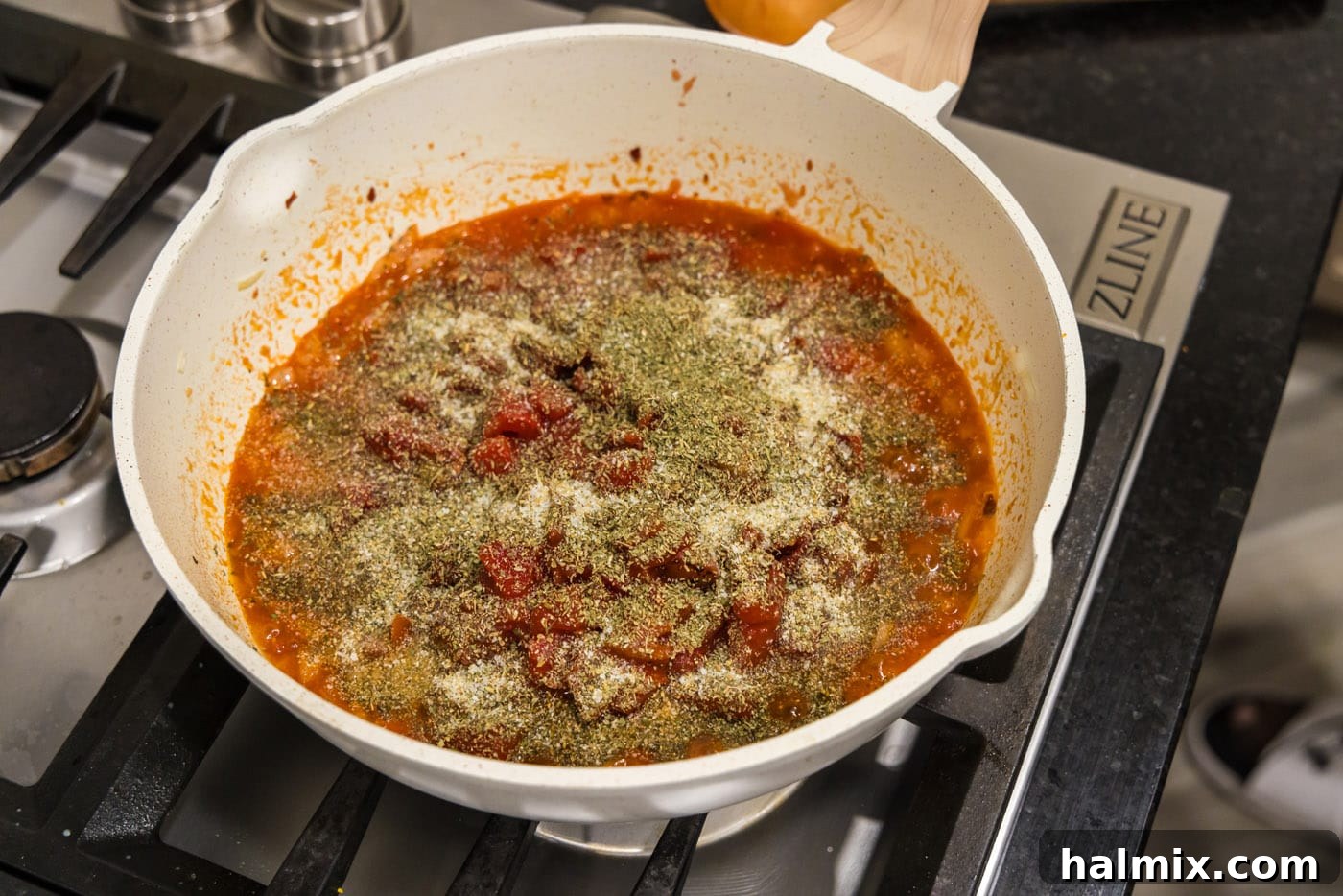 seasonings added to skillet with parmesan cheese and vodka sauce