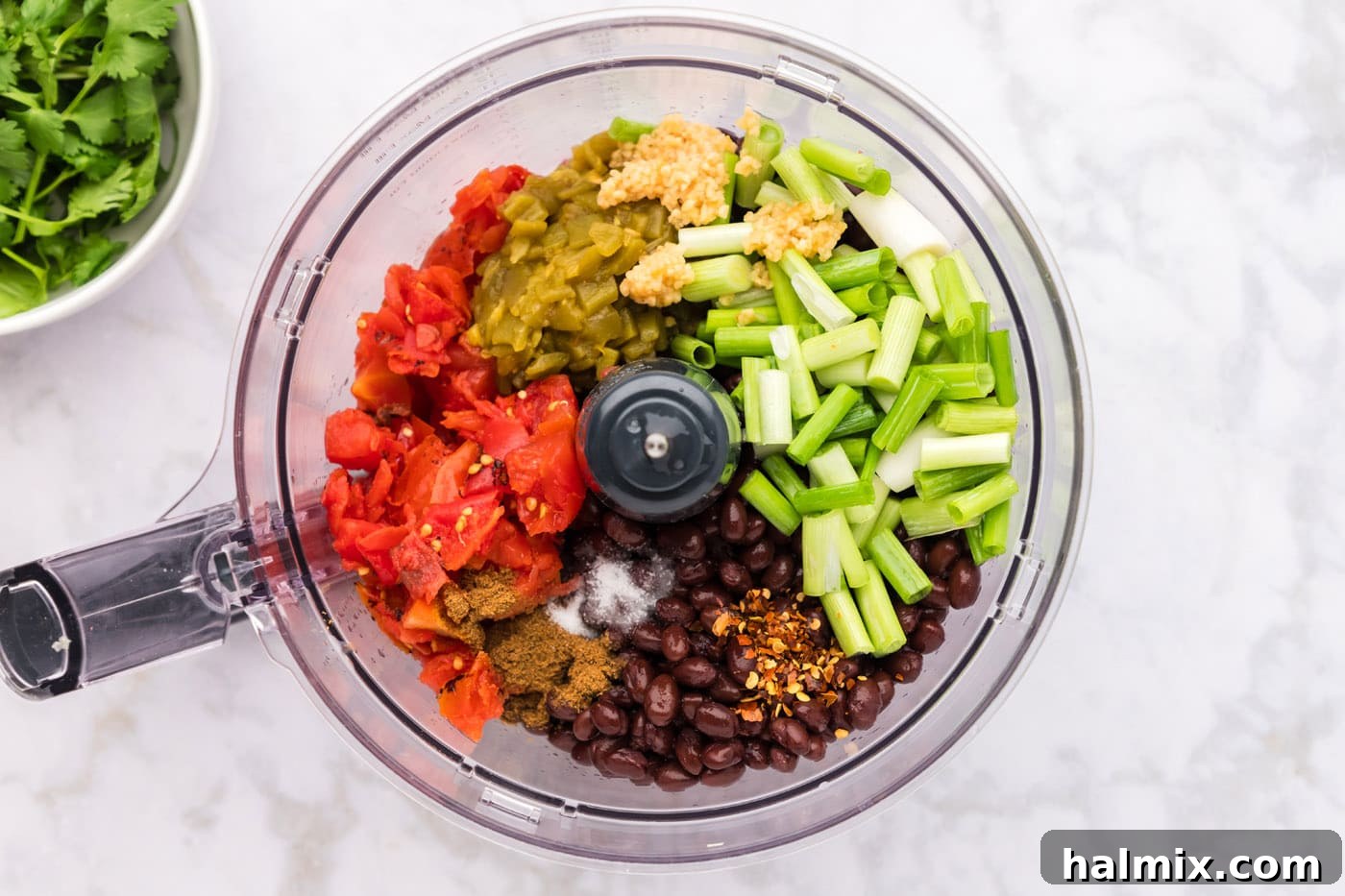 Ingredients for black bean dip loaded into a food processor