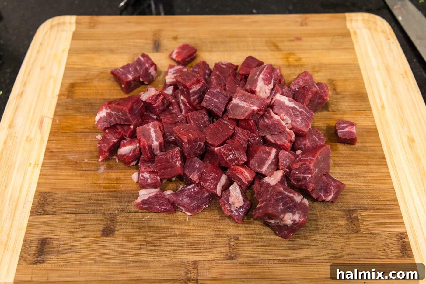 flank steak cubed on a cutting board