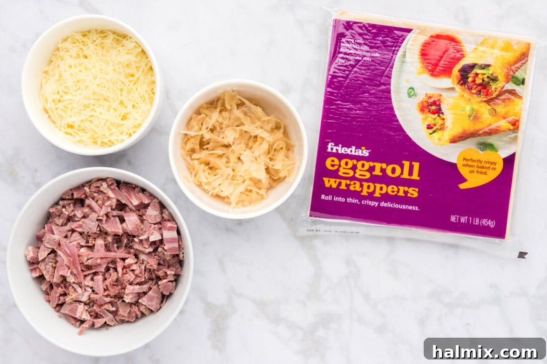 Crispy Reuben Egg Rolls 4 A flat lay photo showing the simple ingredients for Reuben Egg Rolls: egg roll wrappers, a bowl of shredded Swiss cheese, a pile of chopped corned beef, and sauerkraut.