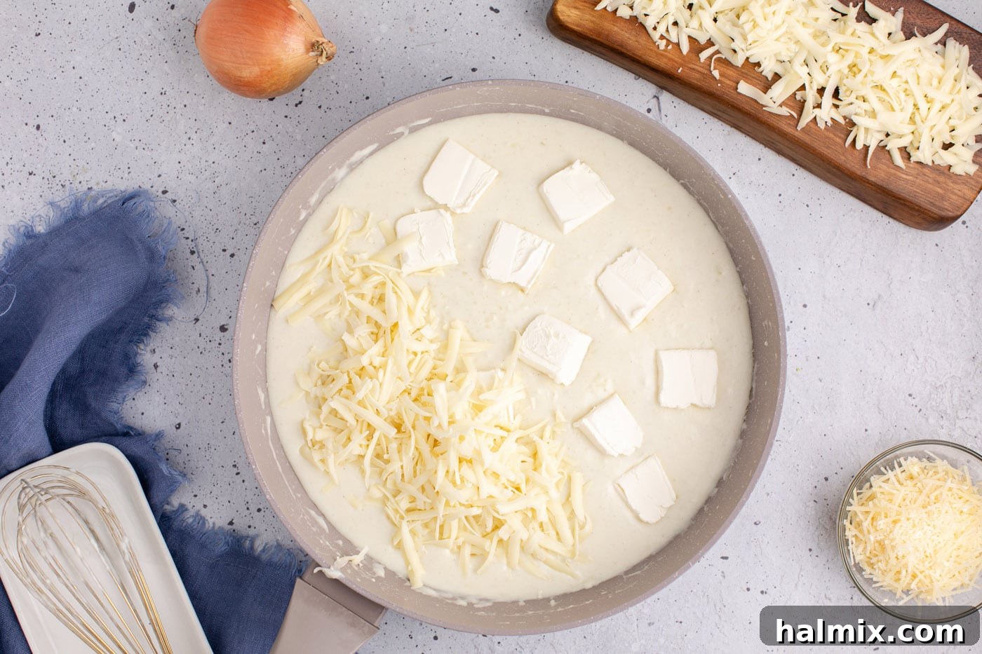 adding butter and mozzarella cheese to roux in skillet