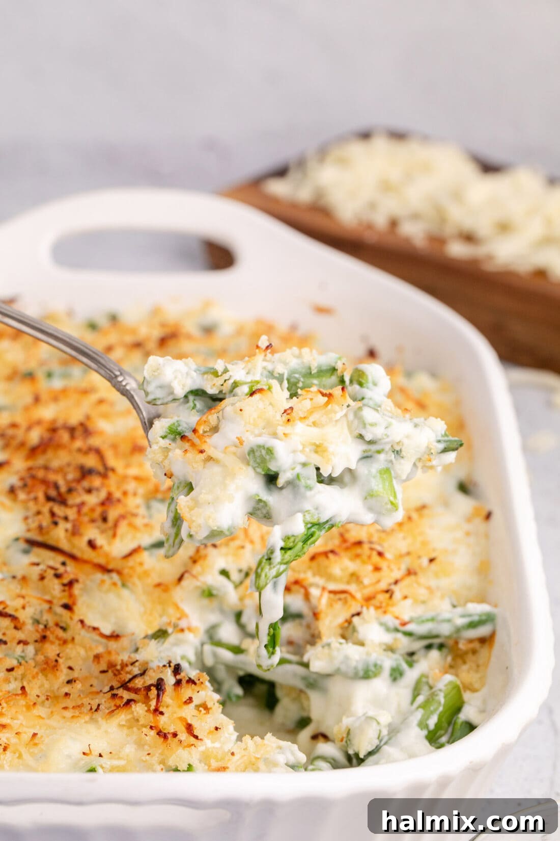 Spoonful of Asparagus Casserole being lifted out of the casserole dish