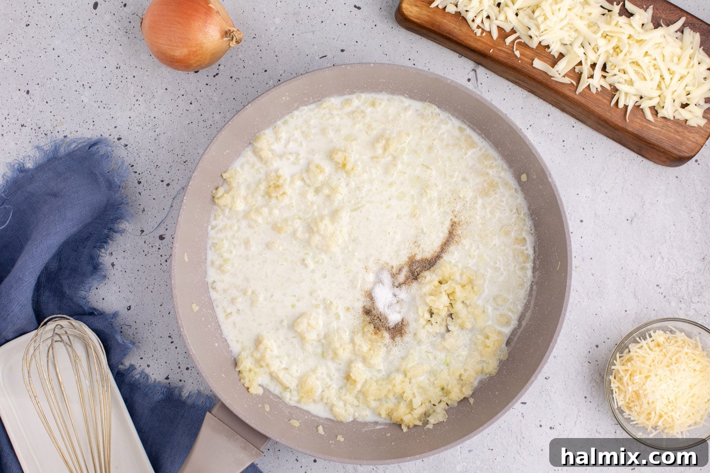 adding milk, salt, and pepper to skillet of onion and garlic