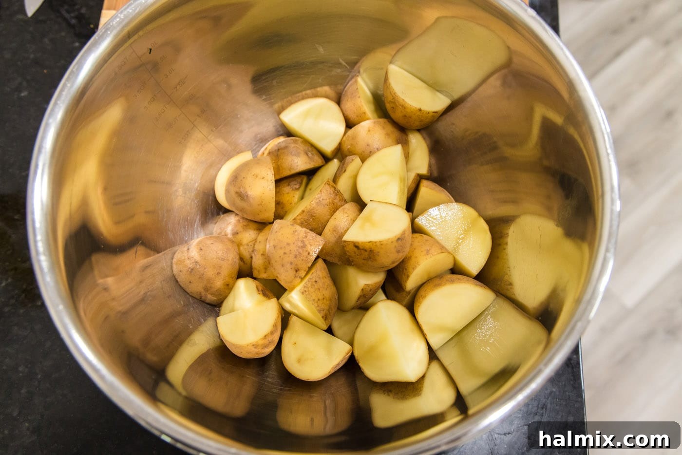Quartered Yukon Gold potatoes neatly arranged in a large mixing bowl, ready for seasoning.