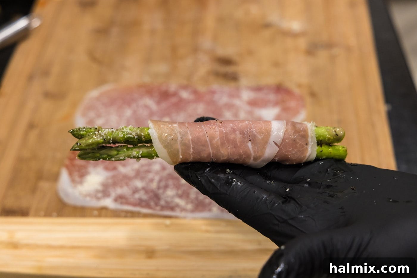 Prosciutto Asparagus Bundles 11 Completed prosciutto wrapped asparagus spears, ready to be placed on the baking sheet.