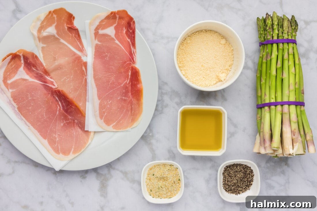 Prosciutto Asparagus Bundles 4 A collection of fresh ingredients laid out on a wooden board, including a bunch of green asparagus, slices of prosciutto, a bowl of grated Parmesan cheese, olive oil, garlic salt, and black pepper.