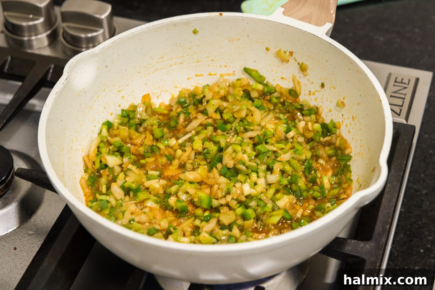 Bayou Red Beans and Rice Legacy 7 the holy trinity vegetables (onion, green pepper, celery) with garlic and spices sautéing in a skillet, creating an aromatic base