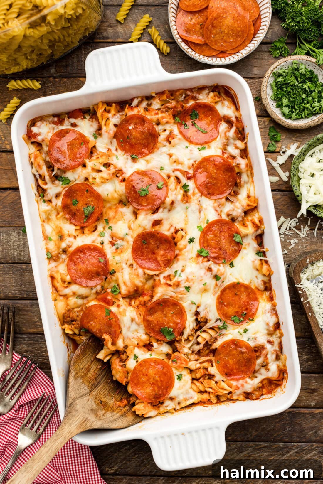 Cheesy Sausage Pepperoni Pizza Bake 2 Serving spoon resting in a Sausage & Pepperoni Pizza Casserole
