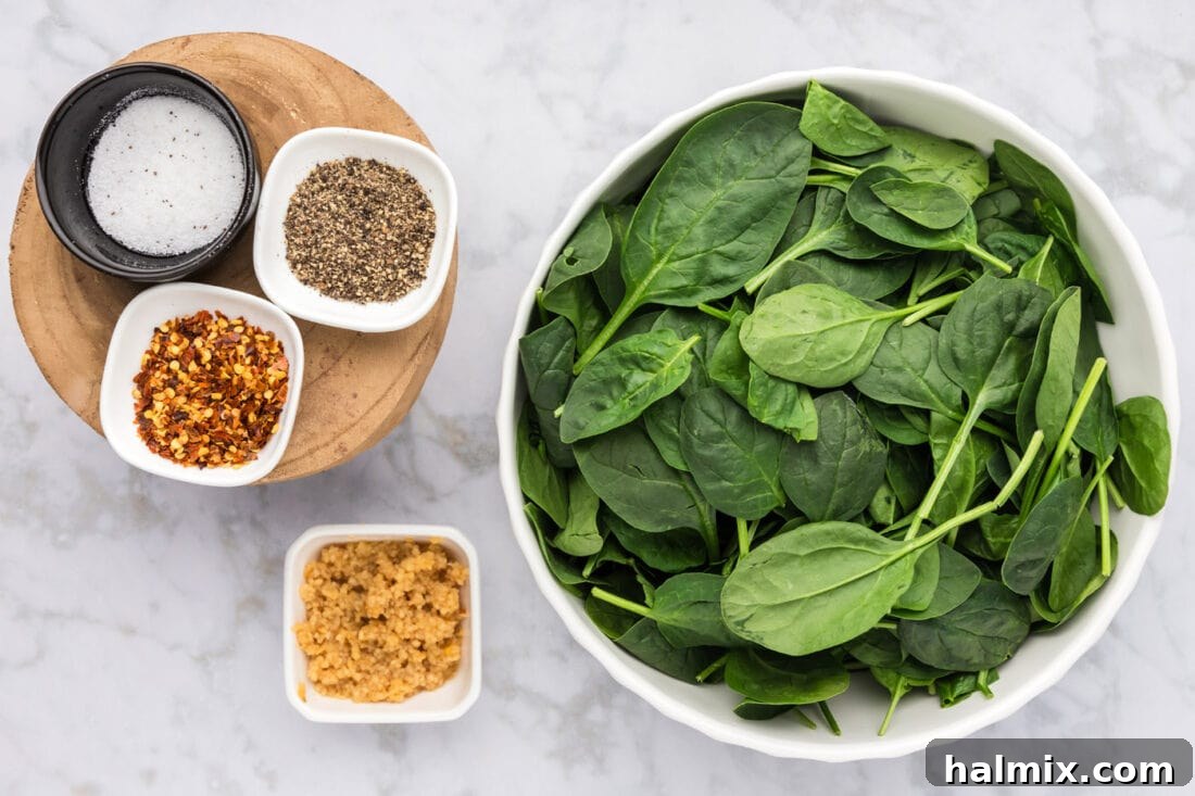 Arrangement of ingredients for Fried Spinach including fresh spinach, minced garlic, red pepper flakes, salt, and pepper