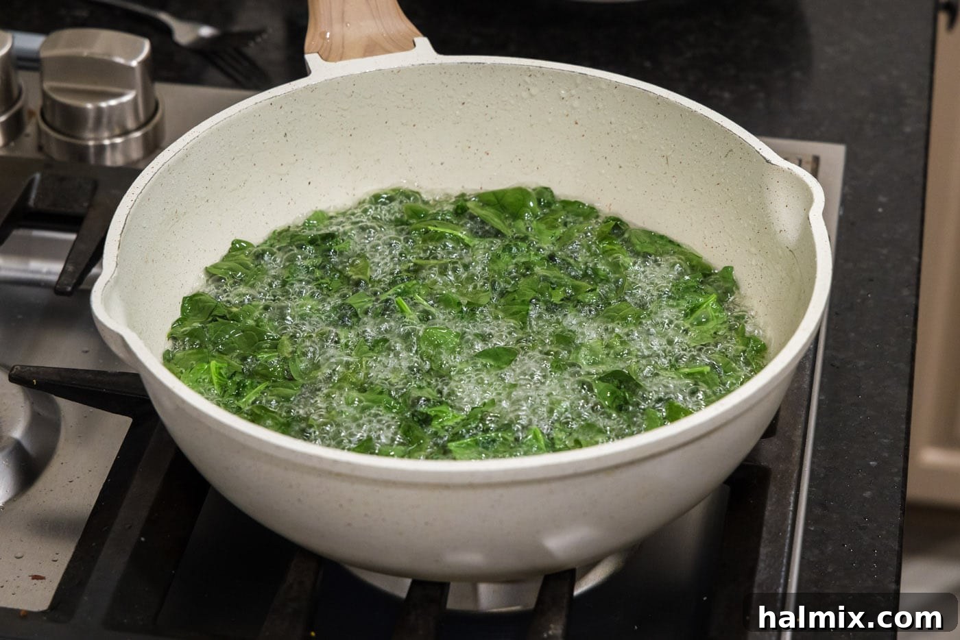 Crispy spinach leaves nearly finished frying, showing the change in color and texture as they become golden and brittle
