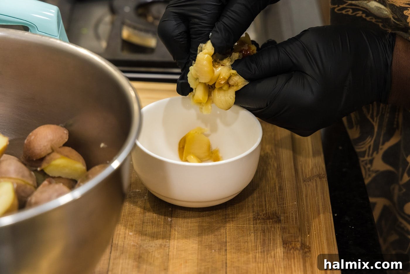 adding roasted garlic to a bowl