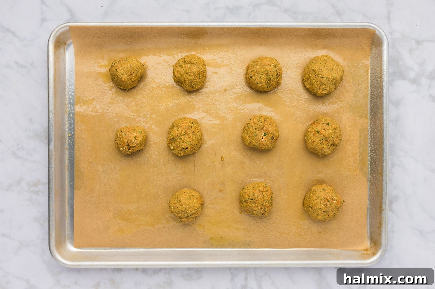 rolled lentil meatball dough on a baking sheet