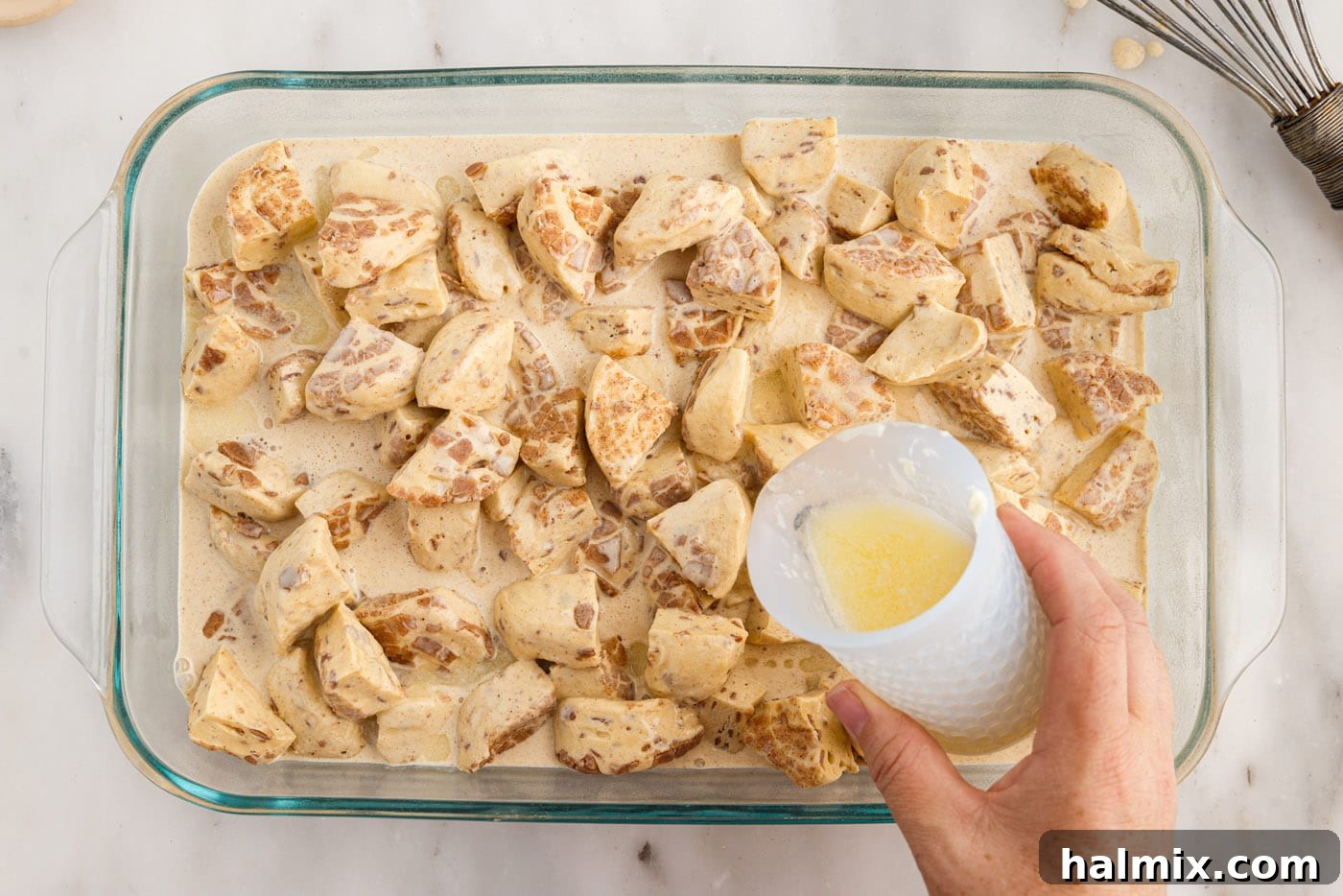 pouring melted butter over cinnamon roll ingredients