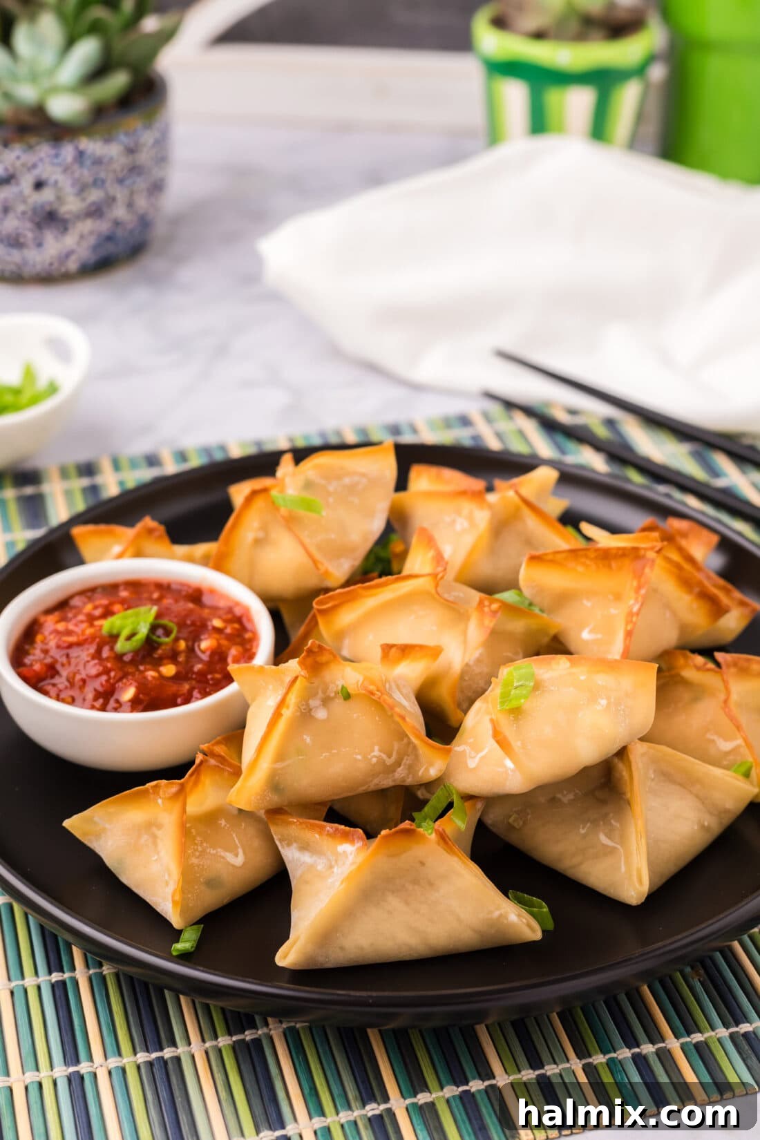 Plate of golden-brown baked Crab Rangoons ready to serve.