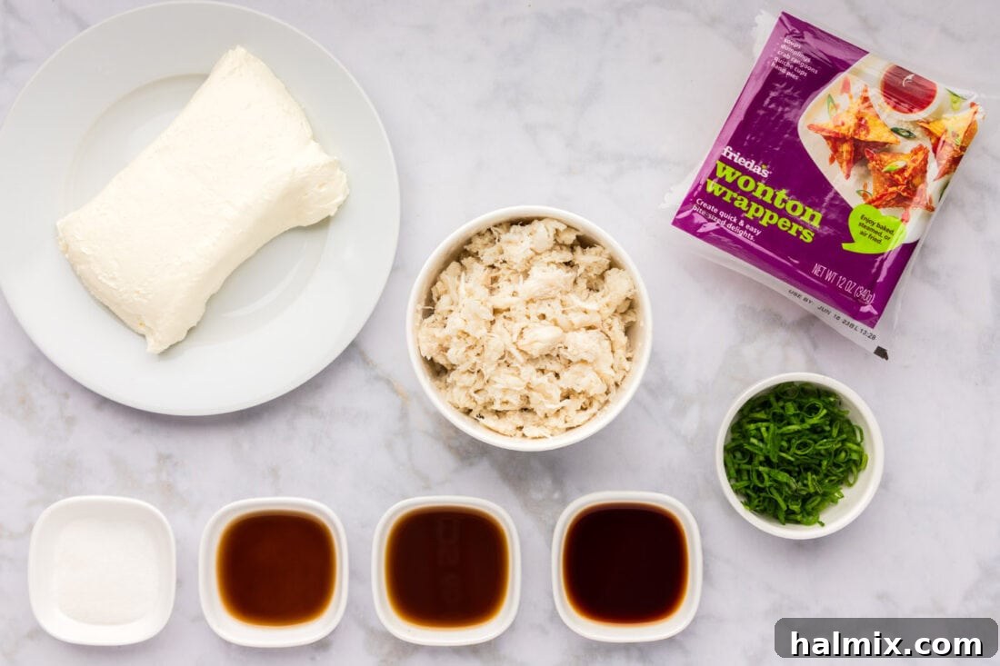 All the fresh ingredients laid out for making Crab Rangoon, including crab meat, cream cheese, sauces, and wonton wrappers.
