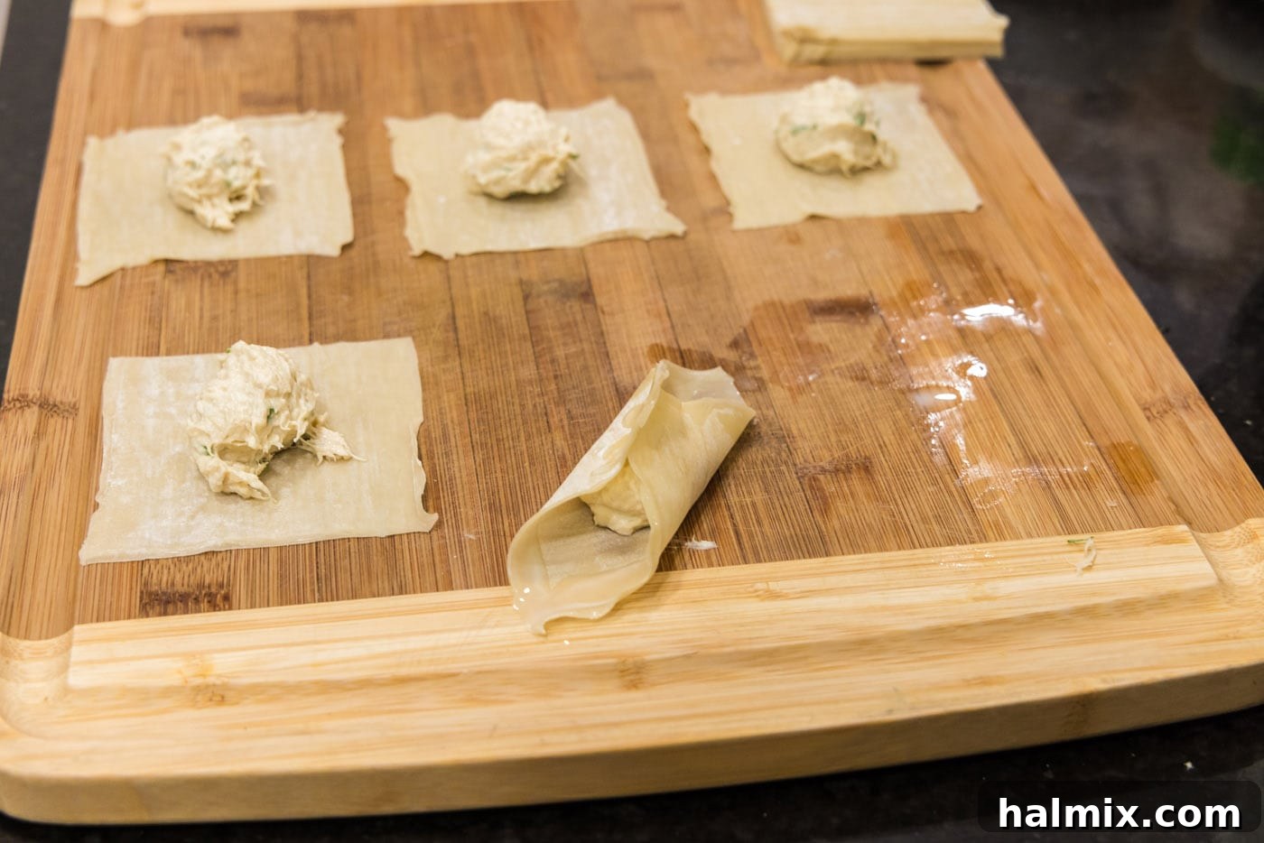 A wonton wrapper folded in half over crab filling, forming a triangle.