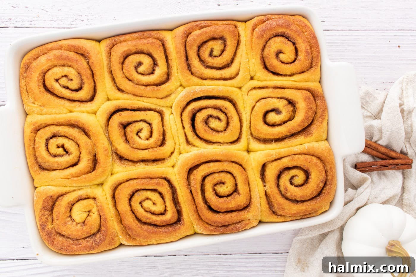 Freshly baked pumpkin cinnamon rolls, golden brown and still in their baking pan