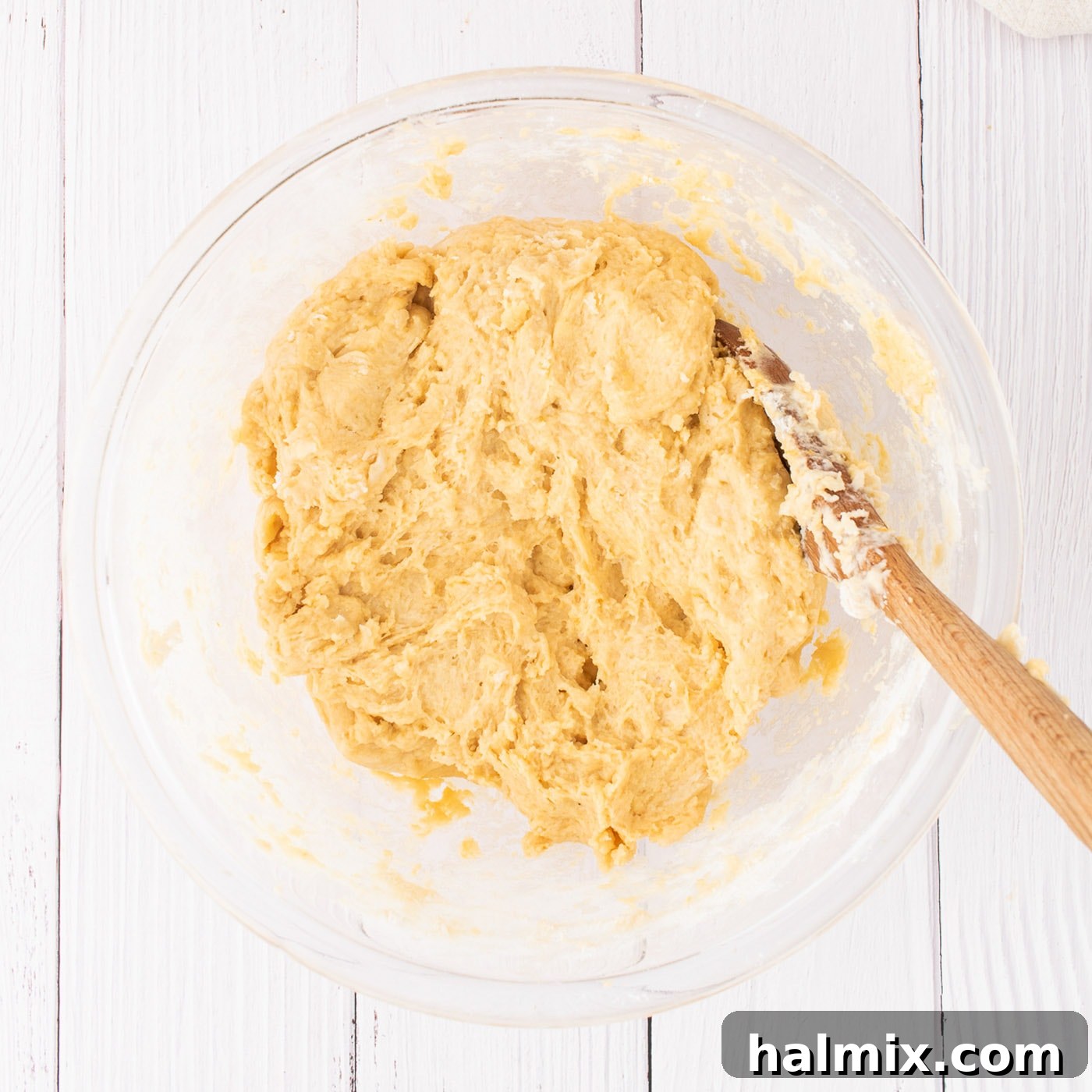 The pumpkin cinnamon roll dough after mixing, resting in a large bowl
