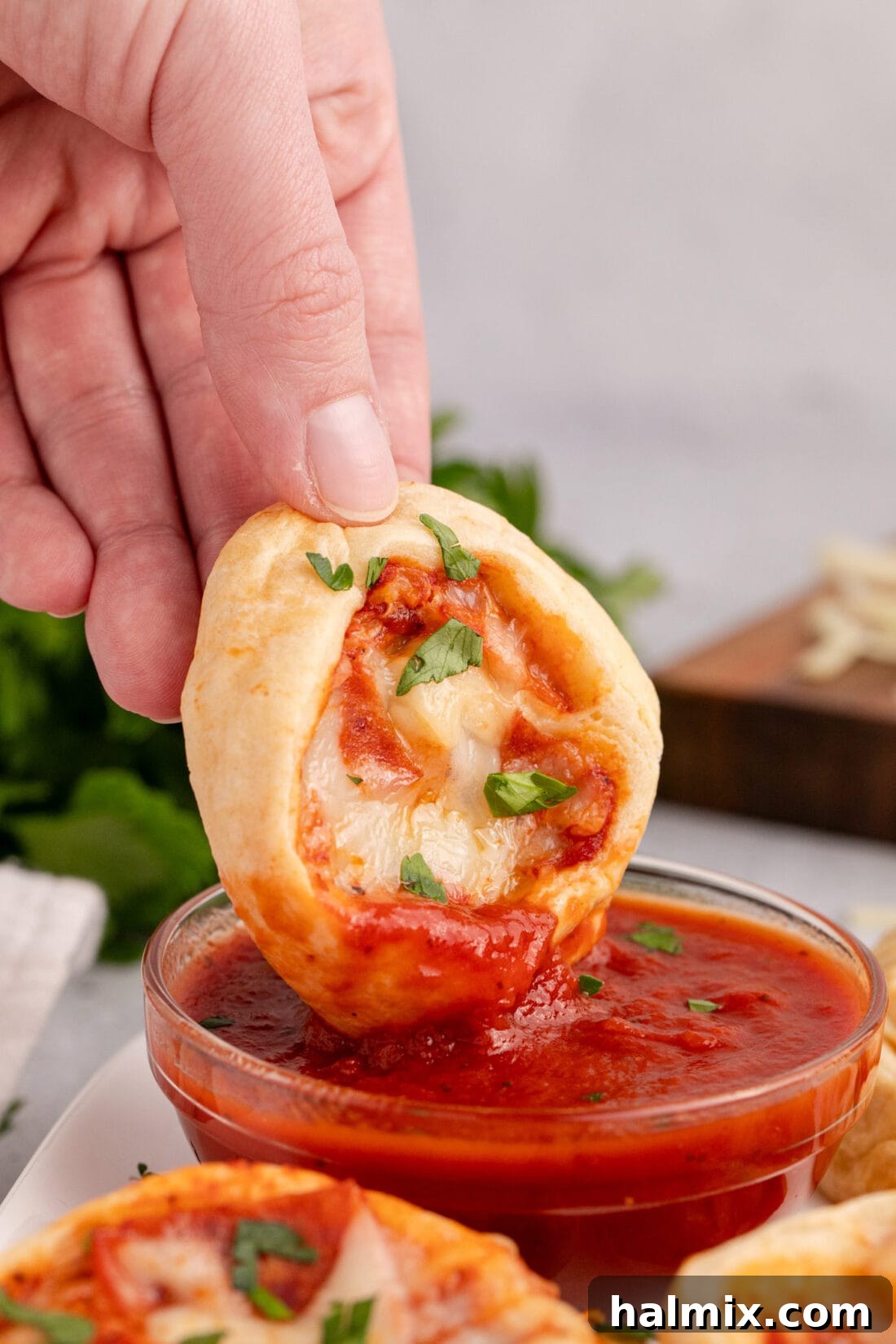 Pizza Pinwheel being dipped into pizza sauce